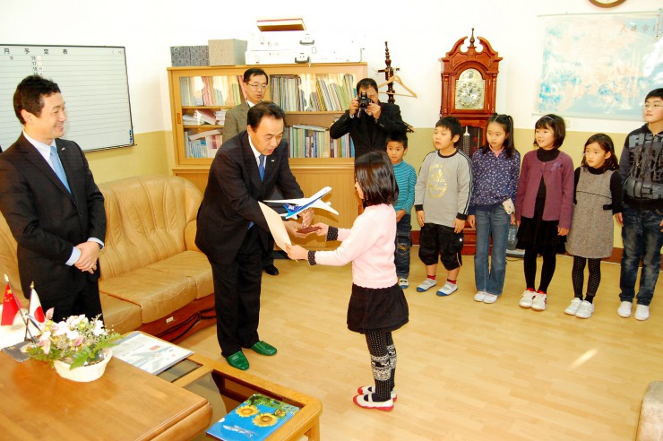 日本人学校の受賞児童に飛行機のレプリカを渡す遠藤支店長（左から2人目）
