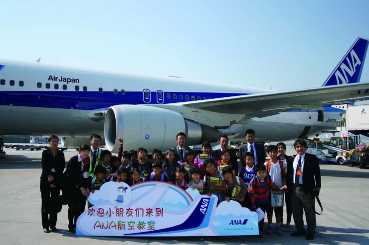 飛行機を背に記念撮影する児童、教諭やANAの社員