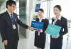 搭乗口で日本航空大連支店の社員から指導を受ける栄久庵さん（中）と門口さん（右）