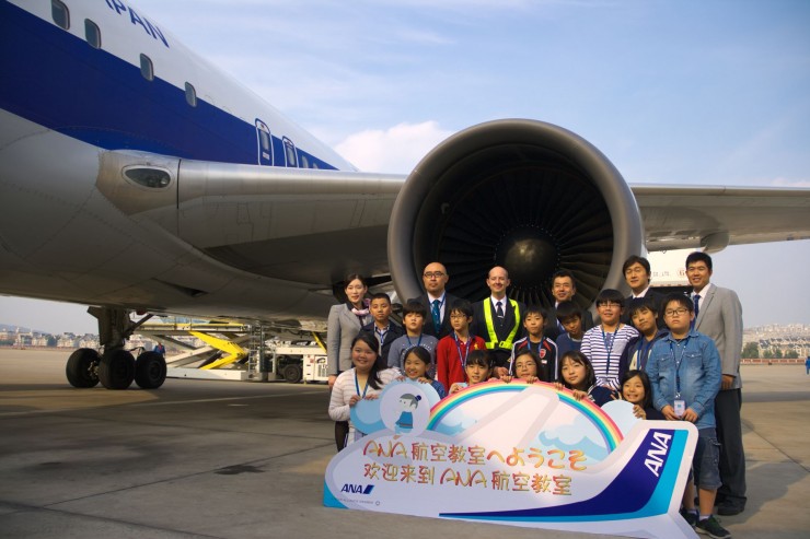 飛行機の前で記念撮影する子どもたち